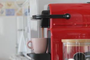 - une tasse de café à côté d'un grille-pain rouge dans l'établissement El Rincón del Reloj, à Llanes