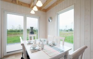 une salle à manger avec une table, des chaises et des fenêtres dans l'établissement Seeperle, à Olpenitz