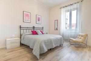 a bedroom with a bed and a chair and a window at Piombino Apartments - Casa Collodi in Piombino