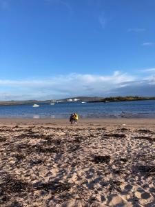 a group of people walking on the beach at The Waterside Apartment 6 in Largs