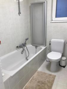 een badkamer met een toilet en een bad bij Urbanstay Suites - Beachfront Apartment In Knokke in Knokke-Heist