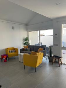 salon z żółtymi krzesłami i kanapą w obiekcie Villa Luisa Puerto del Carmen w Puerto del Carmen