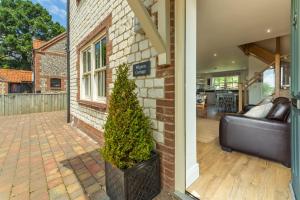 a living room with a couch and a christmas tree at Wigeon Cottage in Thornham