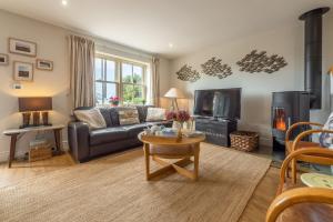 a living room with a couch and a tv at Wigeon Cottage in Thornham