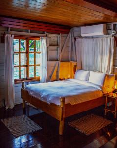 ein Schlafzimmer mit einem Bett in einem Zimmer mit Fenstern in der Unterkunft Casa Acuario Boutique Hotel in Bocas del Toro