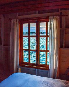 een slaapkamer met een raam met uitzicht op het water bij Casa Acuario Boutique Hotel in Bocas del Toro