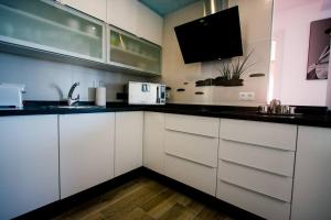 a kitchen with white cabinets and a black counter top at ElBarrioCasablanca in Nerja