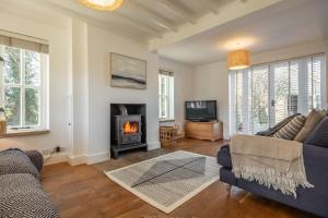 a living room with a couch and a fireplace at Marigold Cottage in Docking