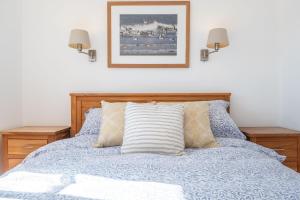 a bedroom with a blue bed with two night stands at Marigold Cottage in Docking