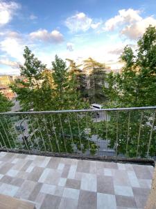 a balcony with a fence with trees and a building at Room 27 in Kutaisi in Kutaisi