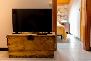 uma televisão de ecrã plano em cima de uma arca de madeira em Petit estudi em Ribes de Freser