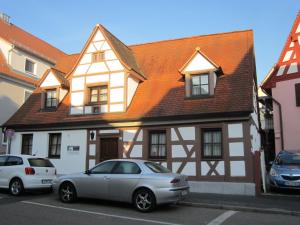 ein weißes Auto, das vor einem Haus parkt in der Unterkunft Gästehaus Engelgasse Herzogenaurach in Herzogenaurach