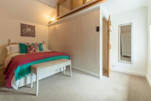 a bedroom with a bed and a table and a window at Sextons Yard Cottage in Docking
