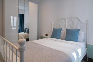 een slaapkamer met een wit bed met blauwe kussens bij Sabbia Suites La Armada in Arrecife