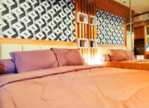 1 Schlafzimmer mit einem großen Bett und 2 Stühlen in der Unterkunft Apartemen grand kamala lagoon in Kayuringin