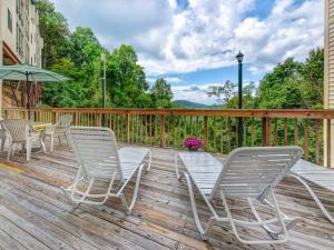 a deck with chairs and a table and an umbrella at Bear Cub Retreat in Gatlinburg