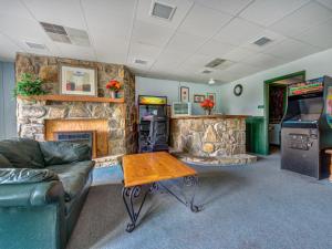a living room with a stone fireplace and a table at Bear Cub Retreat in Gatlinburg
