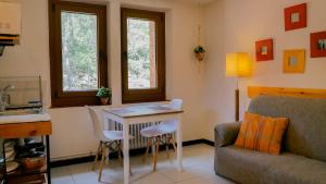 uma sala de estar com uma mesa e cadeiras e um sofá em Petit estudi em Ribes de Freser