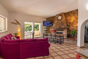 a living room with a red couch and a fireplace at Villa Mariposa exclusive private pool in Budoni