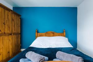 a blue bedroom with a bed with two towels on it at Talbot House in Chester