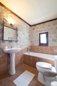 a bathroom with a sink and a toilet and a tub at Twin Castles Maisonettes by RentalsPro - Kriopigi Halkidiki in Kriopigi