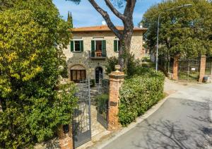 a stone house with a gate in front of it at 15 min da Montepulciano - Villa Chiara in Montefollonico