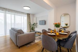 a living room with a table and chairs and a couch at Luxurious Central New Penthouse + Parking in Bucharest