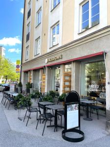 un grupo de mesas y sillas frente a una tienda en Renovated studio Töölö en Helsinki