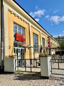 Renovated studio Töölö في هلسنكي: مبنى اصفر مع لوحة مكتوب عليها كارما الراقصة