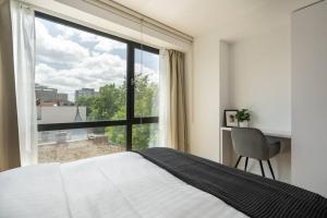 a bedroom with a bed and a large window at Luxurious Central New Penthouse + Parking in Bucharest