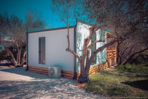 a small white building with a tree next to it at Mobilheim Mate2 in Nin