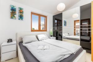 una camera da letto con un grande letto con lenzuola bianche di Apartment Bailey a Pola (Pula)
