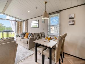 a dining room with a table and a couch at Pheasant Lodge in Nawton