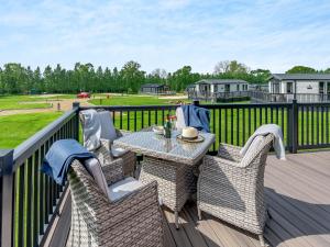 a patio with a table and chairs on a deck at Pheasant Lodge in Nawton