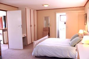 a bedroom with a large white bed in a room at Carol Close Upstairs - A spacious apartment with a view in Durbanville
