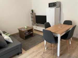 a living room with a table and a refrigerator at Beroun apartments in Beroun