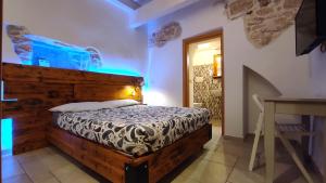 a bedroom with a bed with a wooden headboard at ''B&B Santa Rita Corato fitta camere'' in Corato
