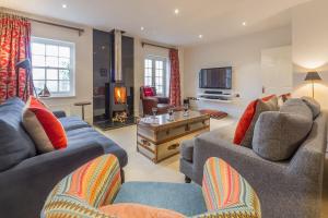 a living room with two couches and a tv at Beech House in Little Walsingham