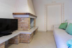 a living room with a fireplace and a couch at Appartamento La Scaletta del Chiasso in Capoliveri