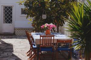 Kanaloa Caparica Surf Lodge في تشارنكه: طاولة عليها كراسي وطاولة عليها زهور