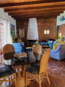 sala de estar con mesa, sillas y sofá en Kanaloa Caparica Surf Lodge en Charneca
