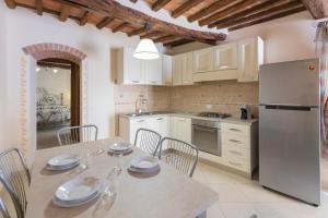 a kitchen with a table with chairs and a refrigerator at Appartamento La Scaletta del Chiasso in Capoliveri