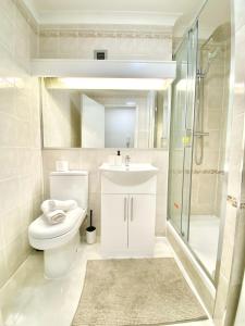 a bathroom with a toilet and a sink and a shower at LUXURY Apt - Balcony- Kensington-24 7 security in London
