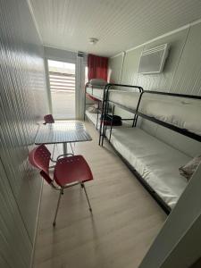 a room with two bunk beds and a table and a chair at Spatii cazare modulare muncitori in Tupilaţi