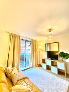 uma sala de estar com um sofá e uma televisão em Luxury Apt- Balcony-Kensington- 24 7 security em Londres