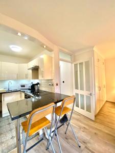 uma cozinha com uma mesa e duas cadeiras em Luxury Apt- Balcony-Kensington- 24 7 security em Londres