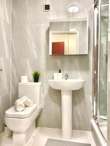 a bathroom with a toilet and a sink at Luxury Apt- Balcony-Kensington- 24 7 security in London