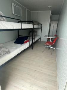 a dorm room with two bunk beds and a table at Spatii cazare modulare muncitori in Tupilaţi