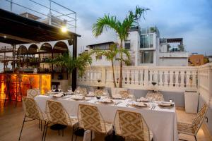 una mesa con manteles blancos y sillas en el balcón en Sol de Alba Hotel Boutique, en Cartagena de Indias
