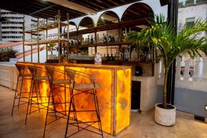 un bar con sgabelli di fronte a un bancone giallo di Sol de Alba Hotel Boutique a Cartagena de Indias